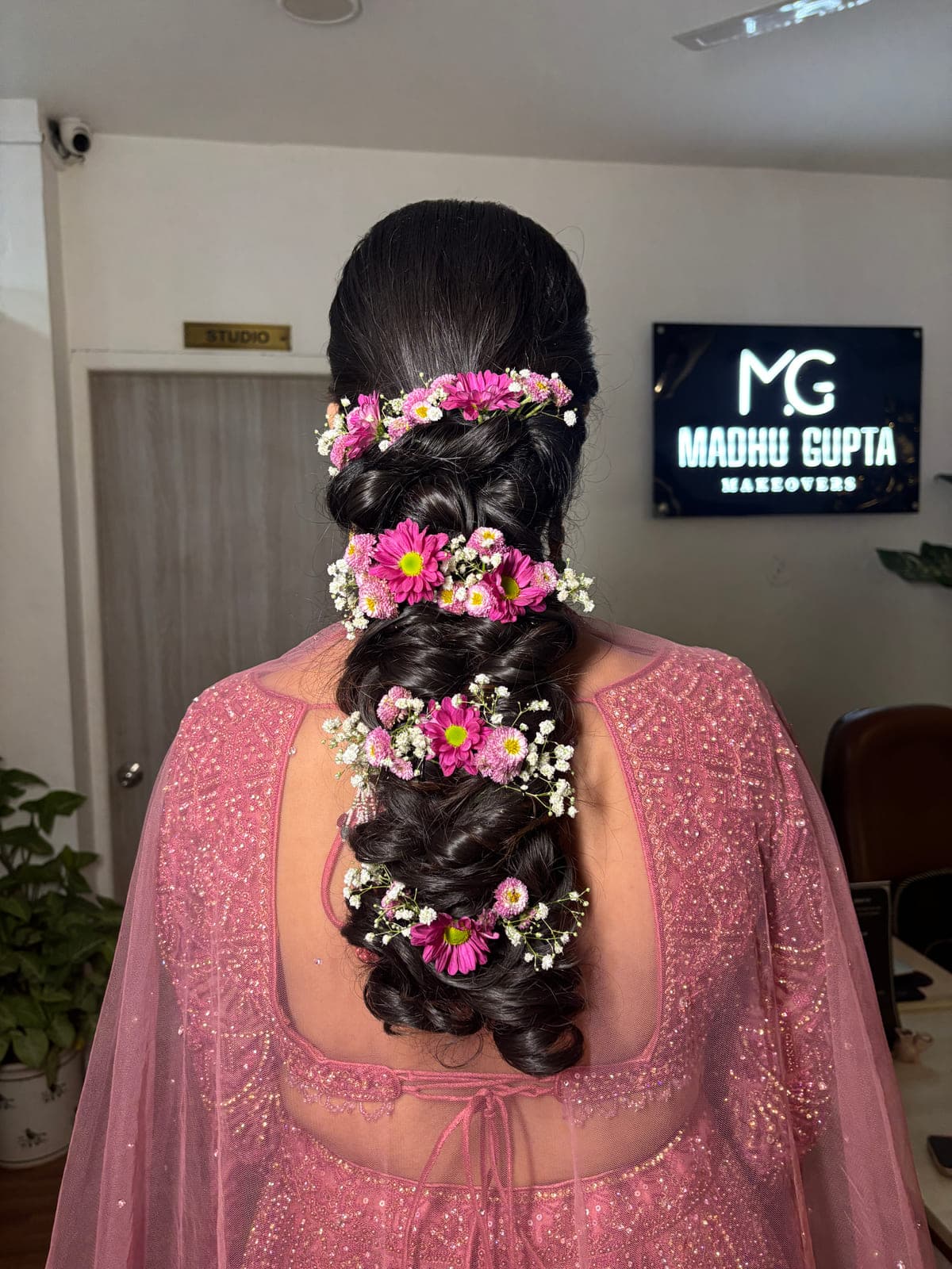 Bridal braid hairstyle dressed with pink and white flowers