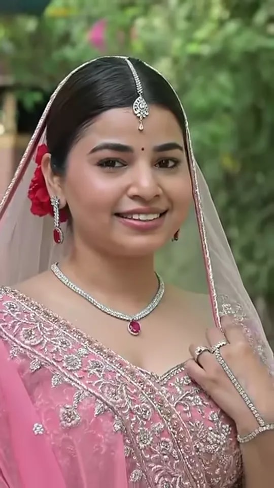 Video thumbnail: bride in a pastel pink lehenga with a veil, diamond necklace with ruby pendant and maang tikka, recreating Kiara Advani's wedding look
