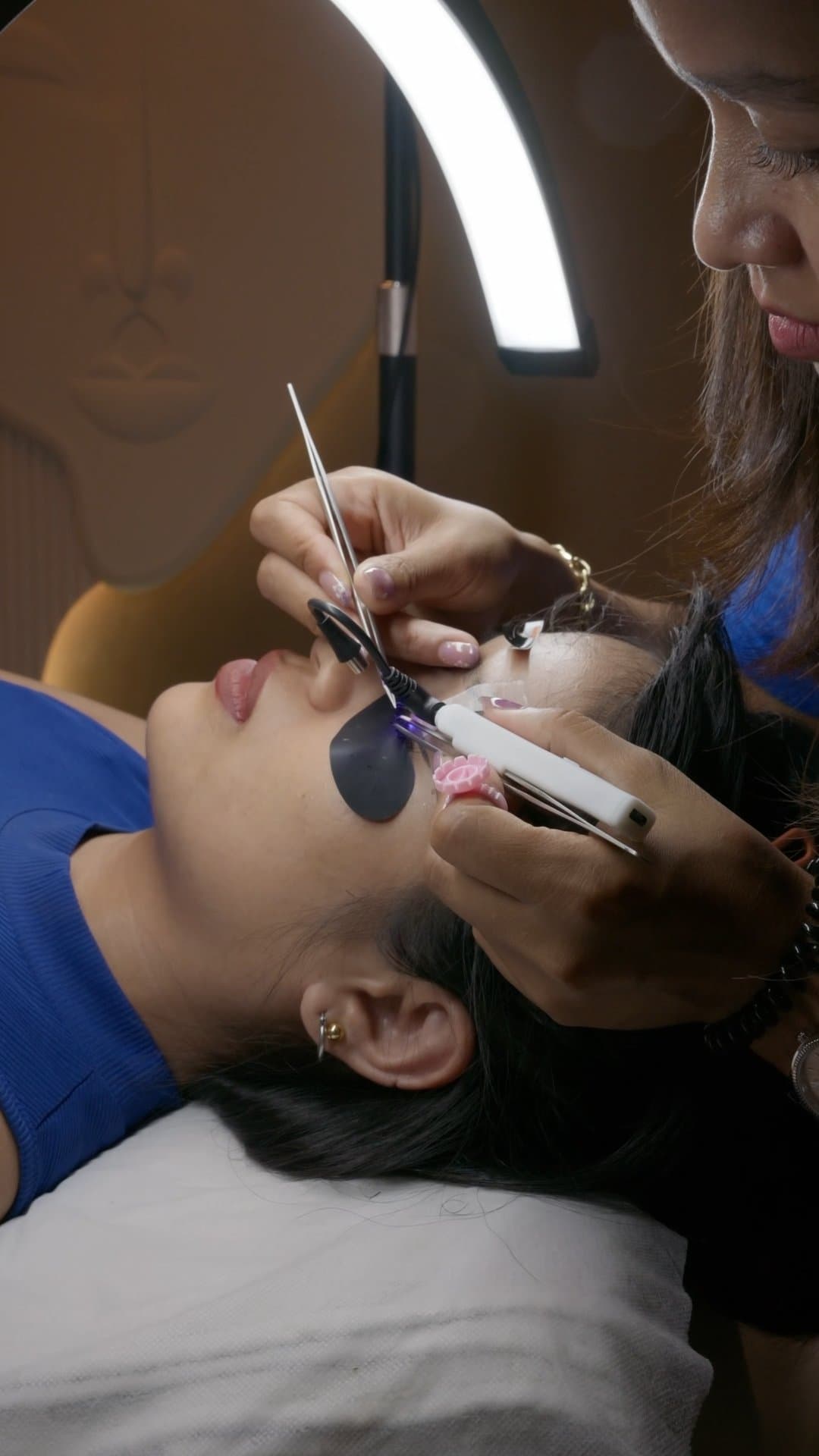 Application of UV eyelash extensions with tweezers and UV LED wand at MG Makeovers
