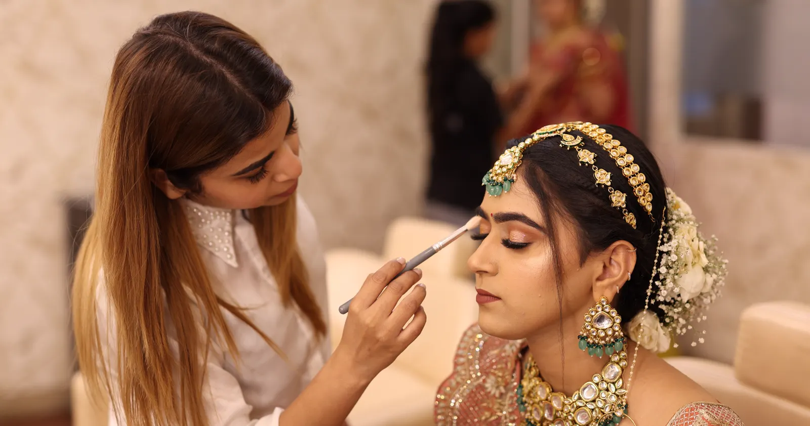 MG Makeovers artist applying eye makeup to a bride in the studio