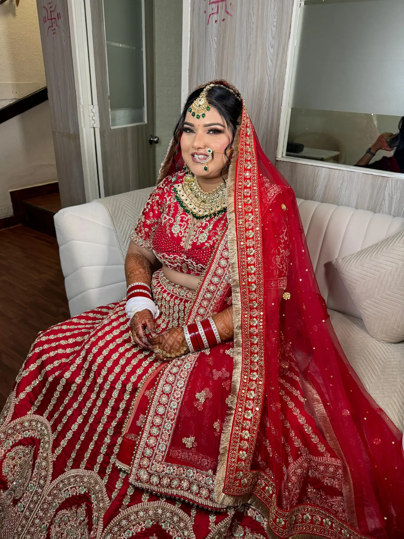 Bride in a red lehenga with bridal makeup by MG Makeovers, Gurugram