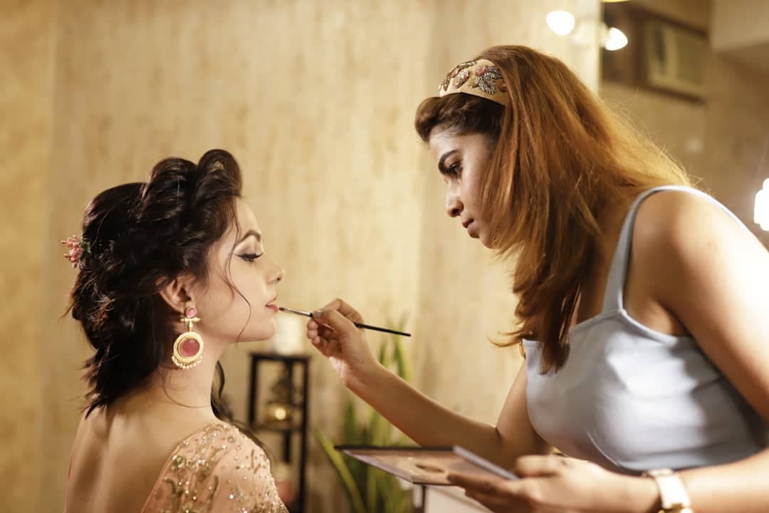 Makeup artist applying lip colour to a model at MG Makeovers