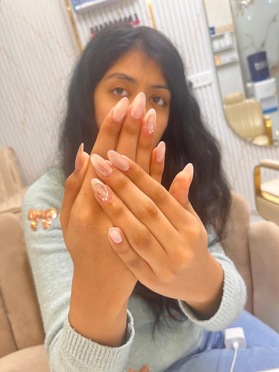 Woman showing off her sparkling ombre nail design at MG Makeovers nail salon in Gurgaon