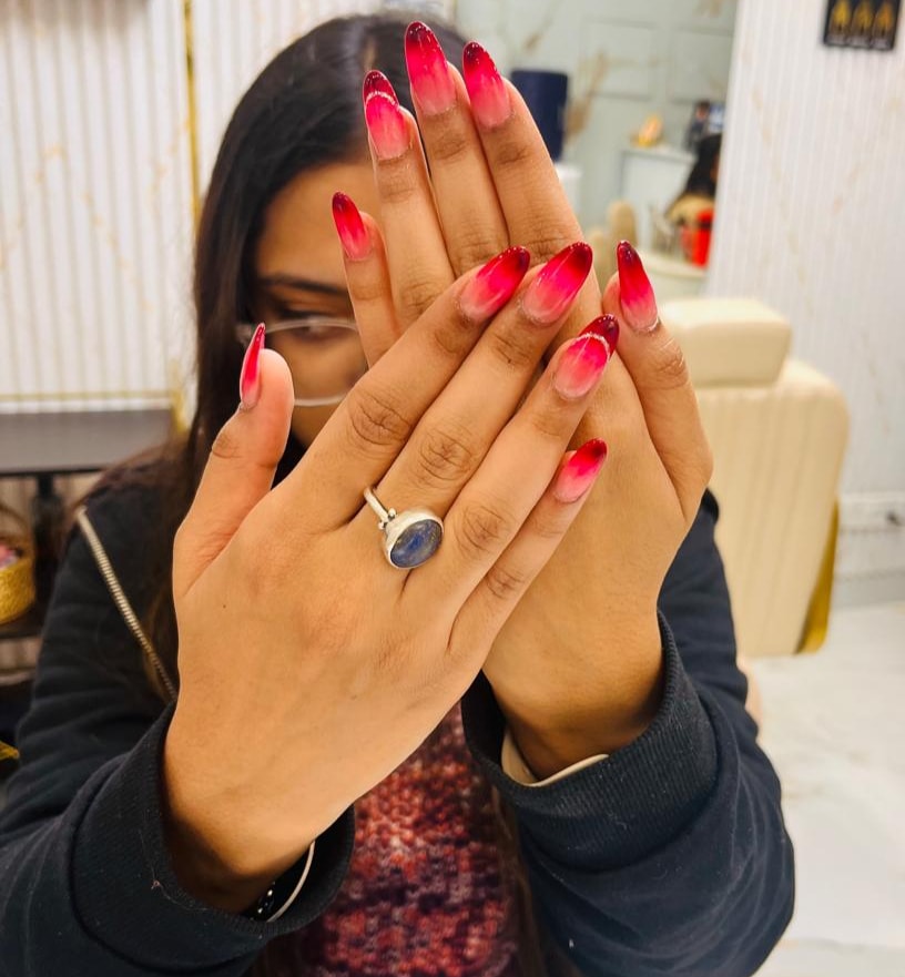 Vibrant red gradient nail design on a client at MG Makeovers, Gurgaon.