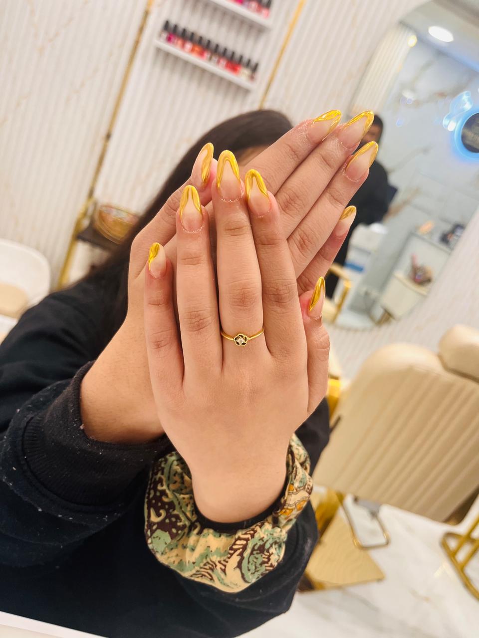 Close-up of hands with bright yellow swirl nail art from MG Makeovers in Gurgaon